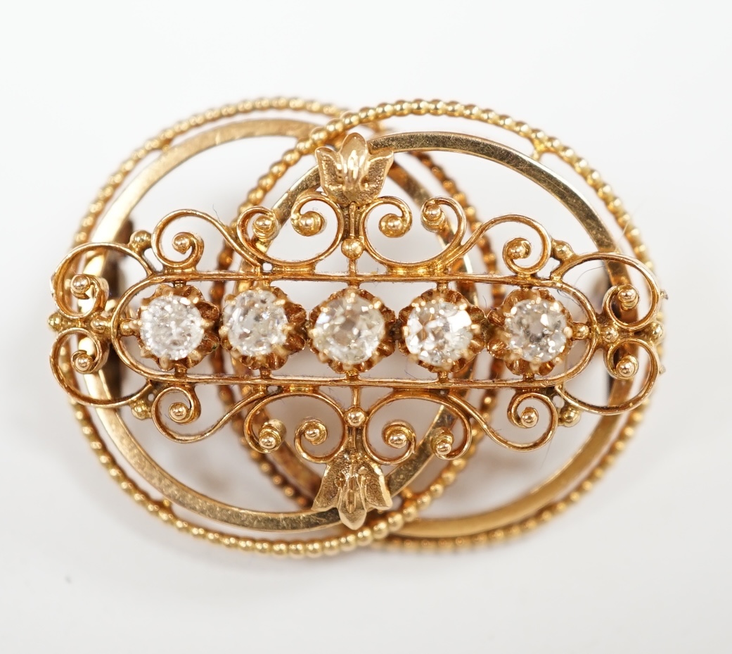 A pierced yellow metal and five stone diamond set double circle brooch, 26mm, gross weight 4 grams. Condition - fair to good